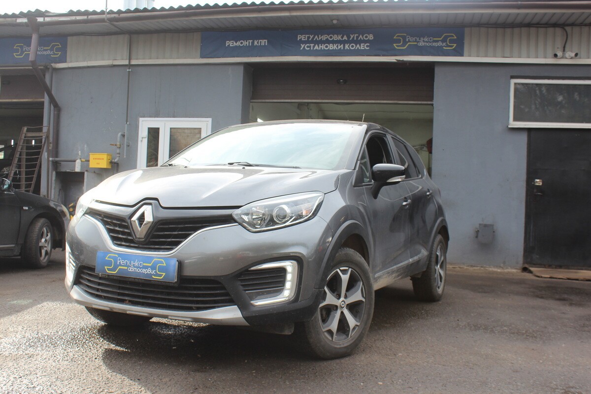 Silver Renault Captur crossover SUV parked outdoors, showing front grille with diamond logo