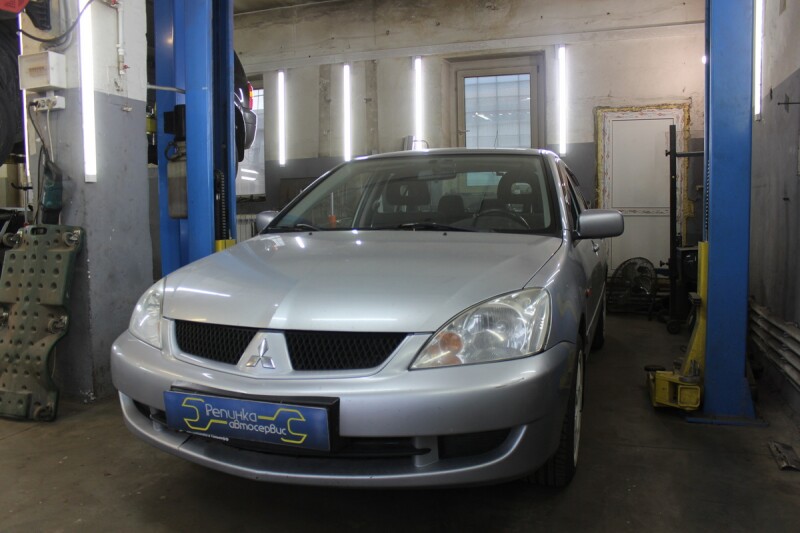 Серебристый Mitsubishi Lancer 9 в боксе автосервиса