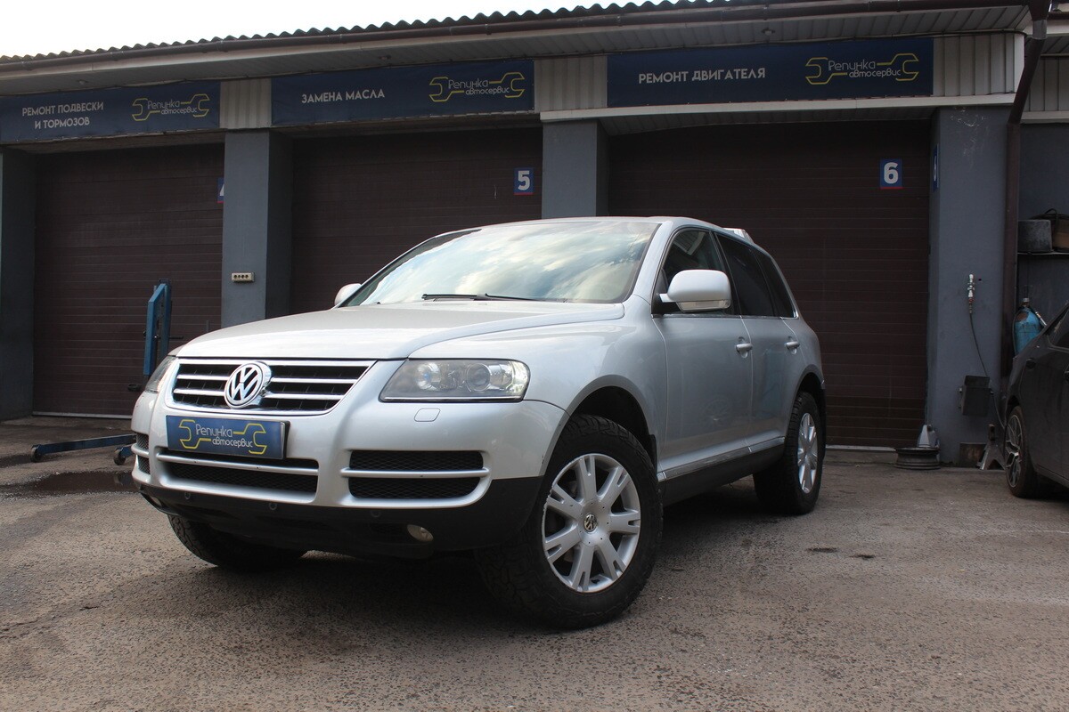 Серебристый Volkswagen Touareg первого поколения во дворе автосервиса