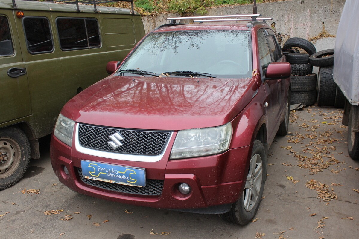 Красный Suzuki Grand Vitara на площадке автосервиса